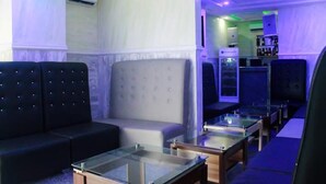 A modern lounge area with seating, a bar, and ambient lighting. - Demeg Hotel And Suites (Lagos)