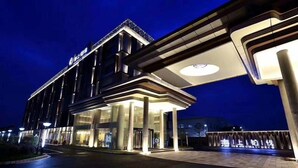 A modern hotel entrance with a covered walkway, large columns, and illuminated signage. - Shanghai Deco Hotel (SHANGHAI)