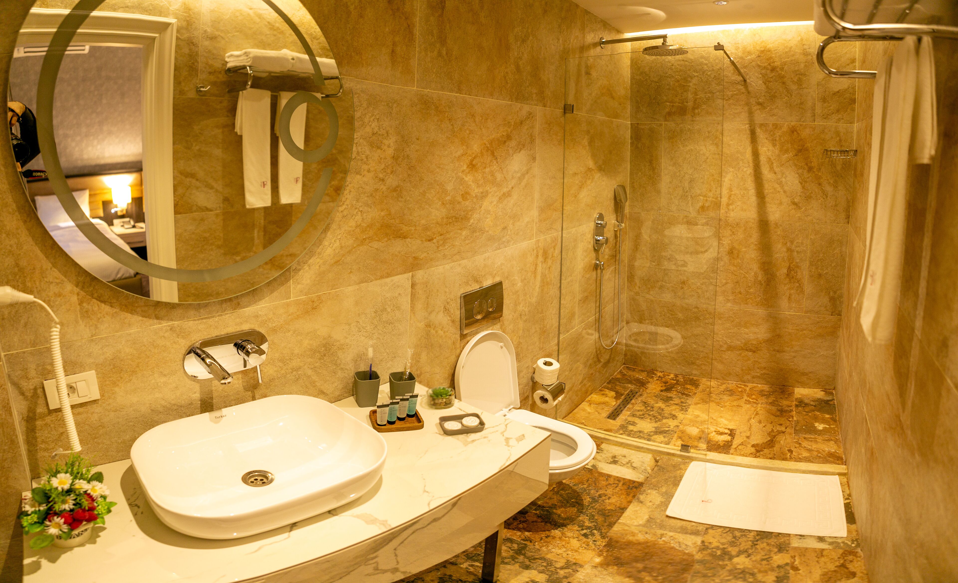 A bathroom with a sink, toilet, and shower.