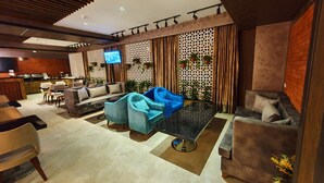 Un espace de détente moderne avec des canapés, une table basse et un écran de télévision.