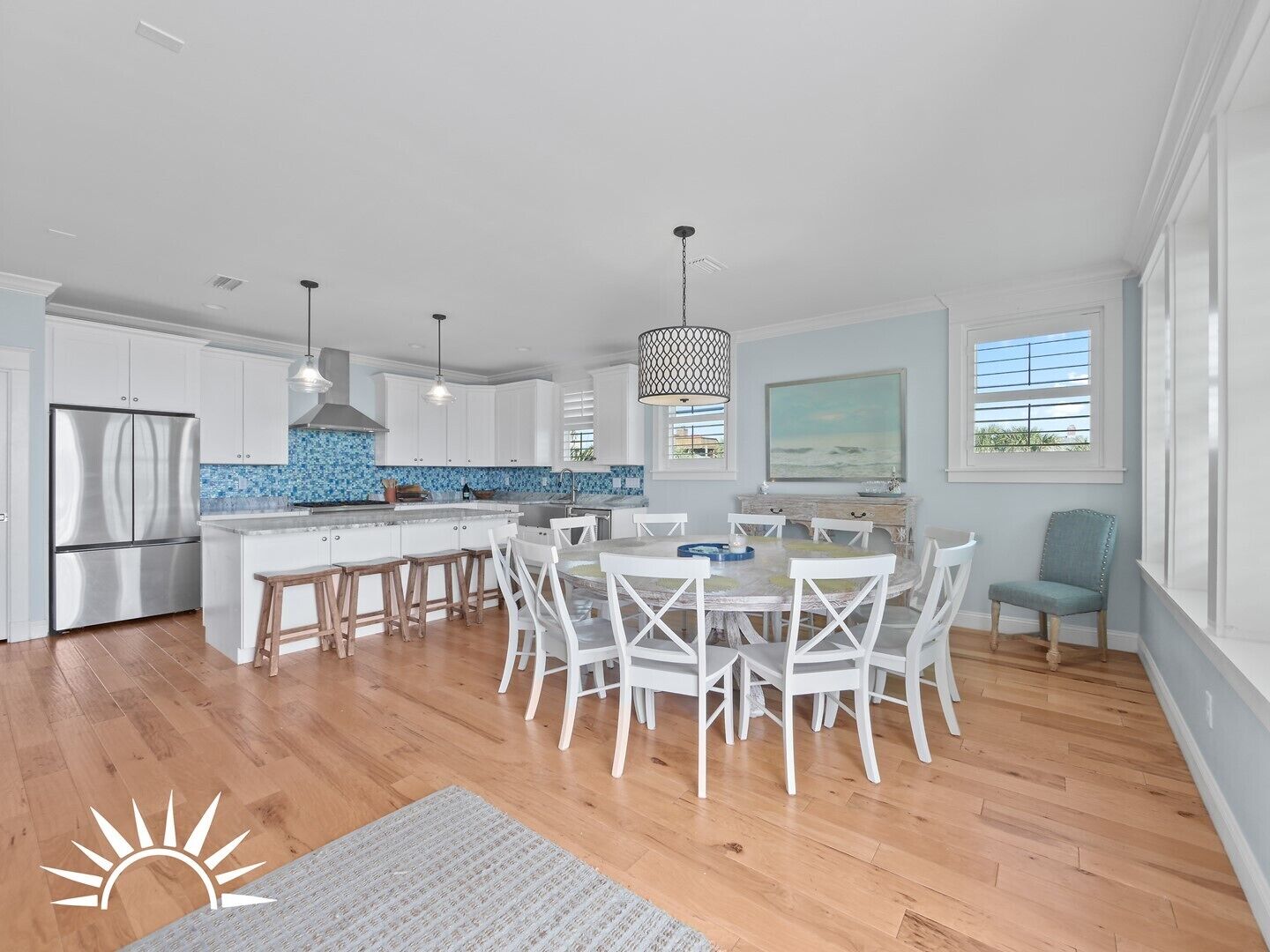 A modern kitchen with white cabinets, a stainless steel refrigerator, and a blue backsplash.