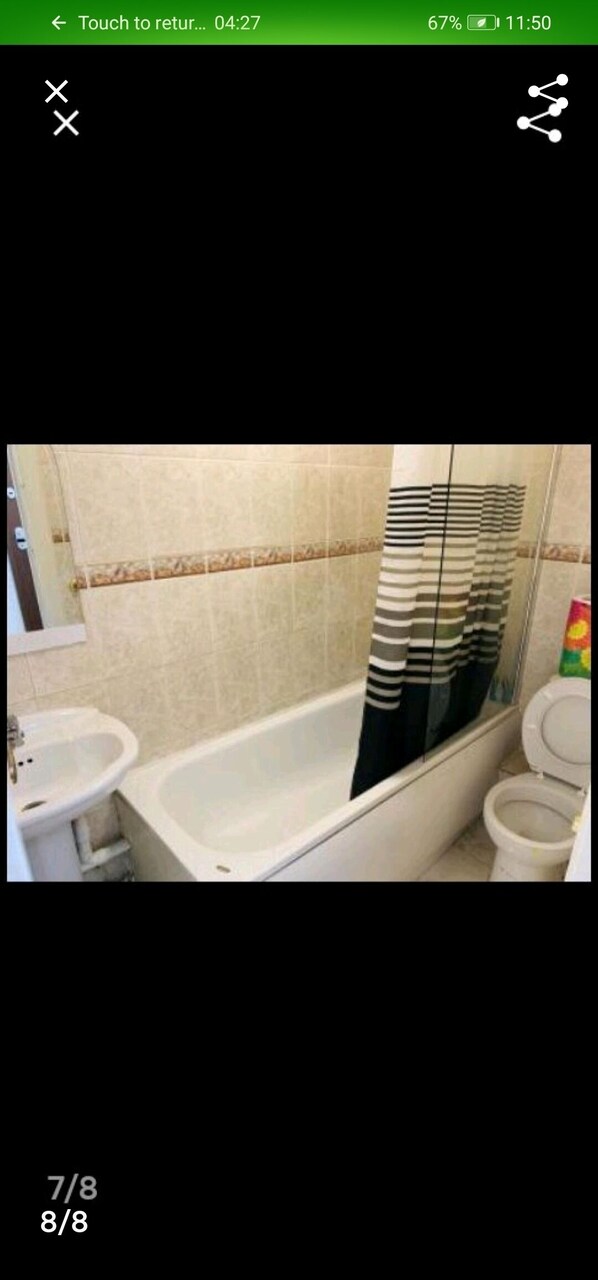 A bathroom with a bathtub, a sink, and a toilet.
