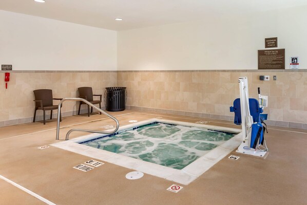 Zona de piscina con jacuzzi, sillas de descanso y cartel de prohibición de buceo.