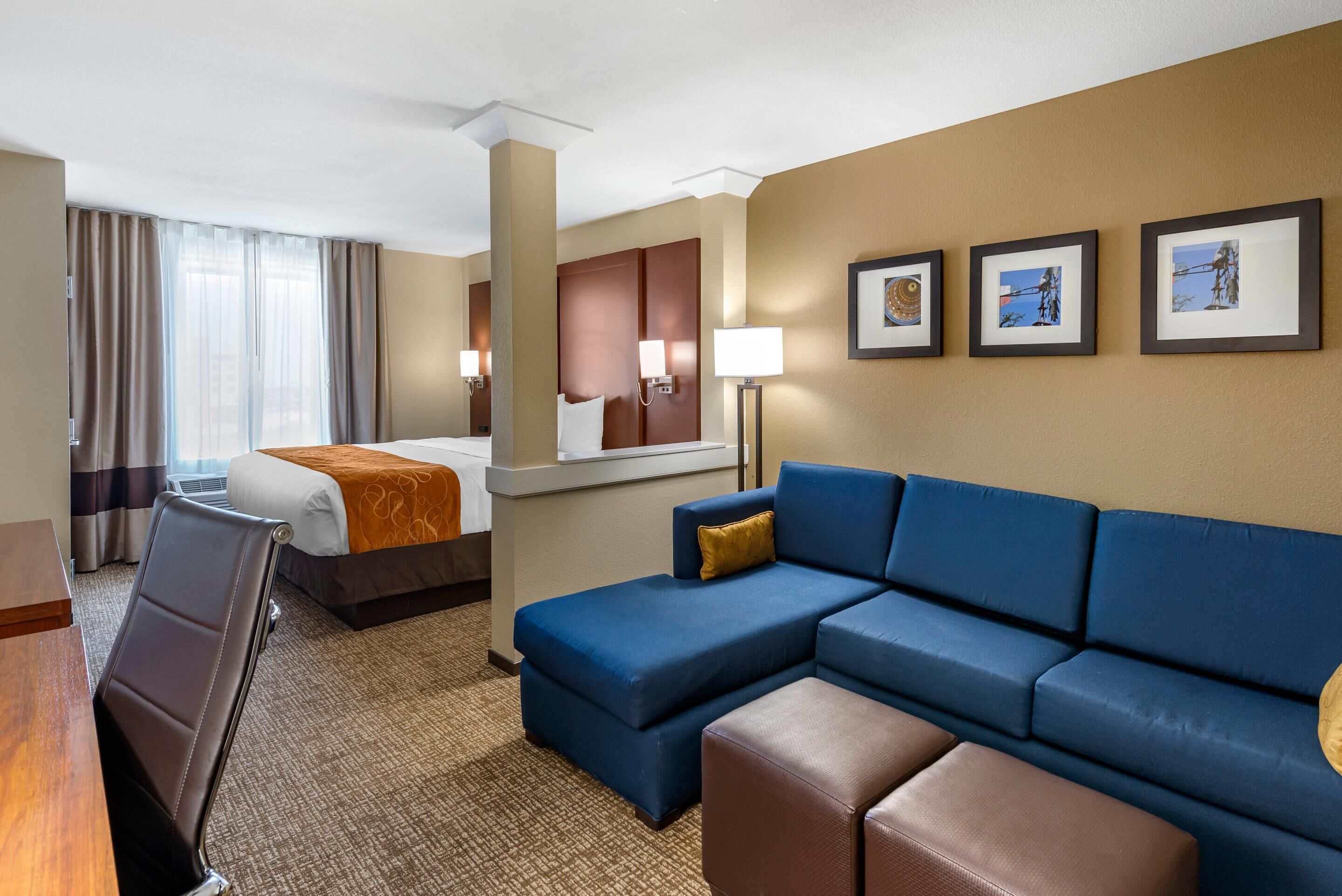 Una habitación de hotel con cama, sofá, escritorio y silla.
