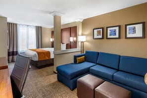 A hotel room with a bed, a sofa, a desk, and a chair. - Comfort Suites Midland West (Midland)