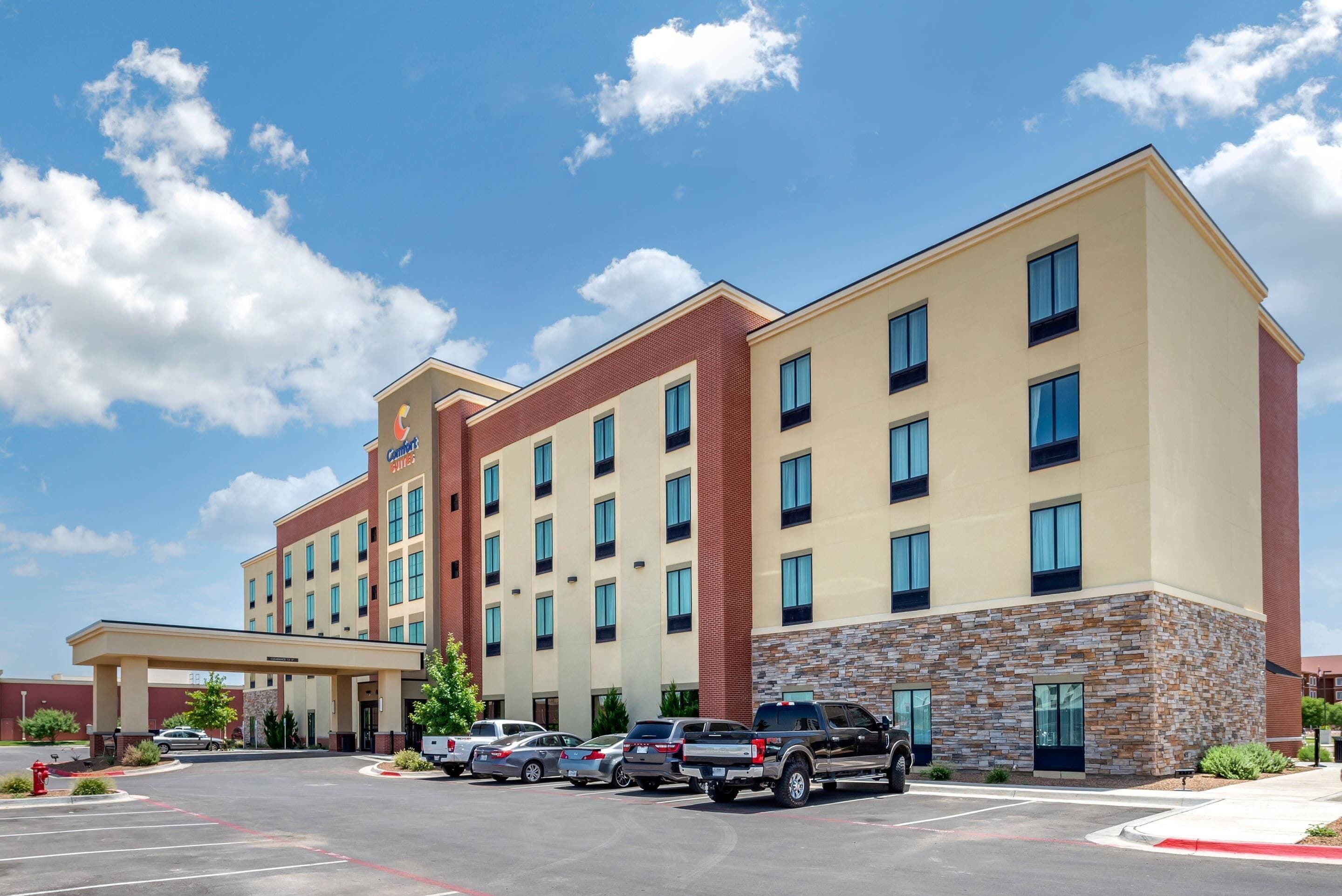 A multi-story hotel with a brick facade and a stone accent wall.