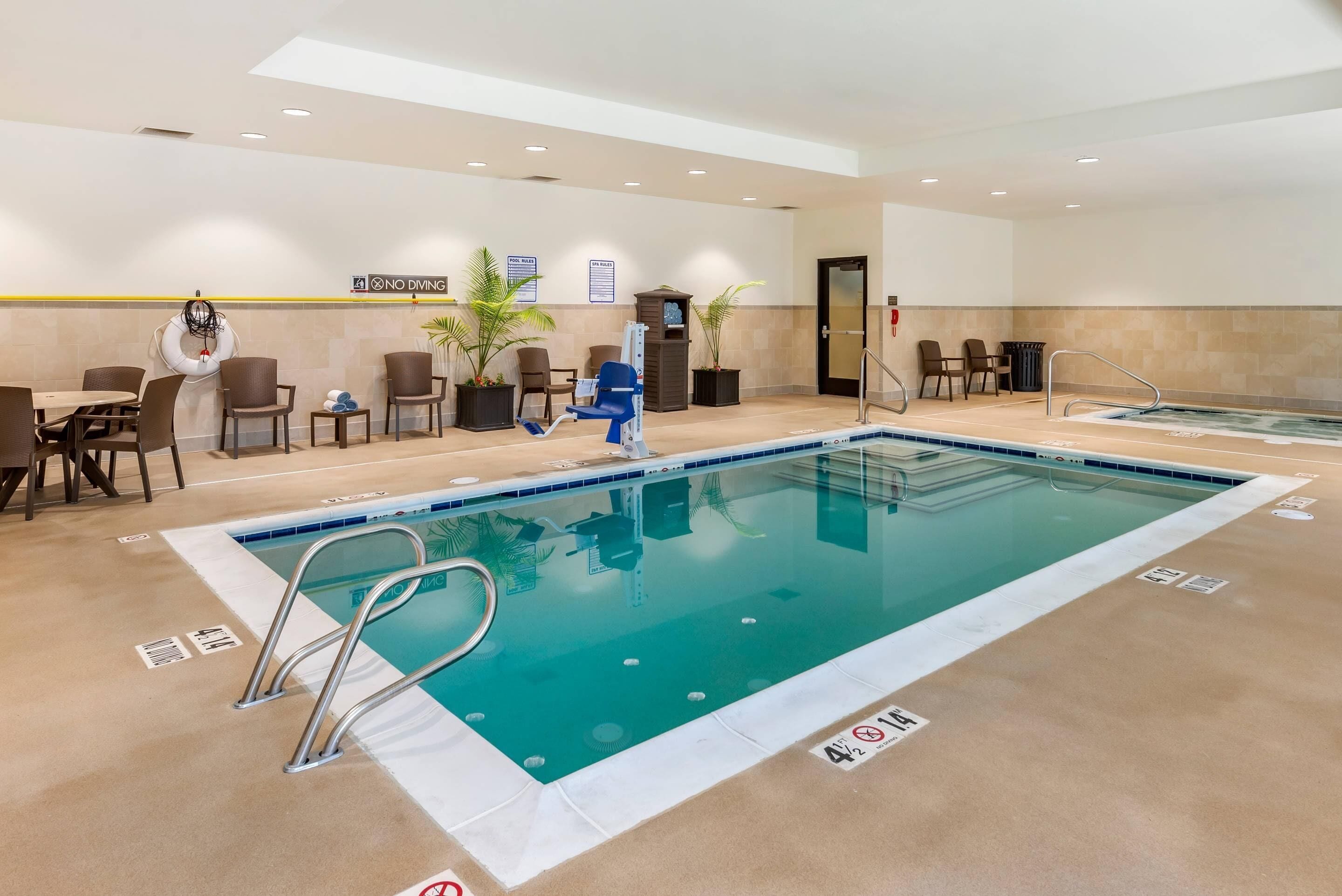 Une piscine d’hôtel équipée d’un poste de surveillance pour sauveteur, de chaises longues et d’un espace spa.