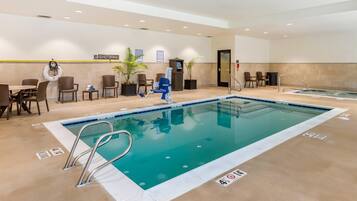 Une piscine d’hôtel équipée d’un poste de surveillance pour sauveteur, de chaises longues et d’un espace spa.