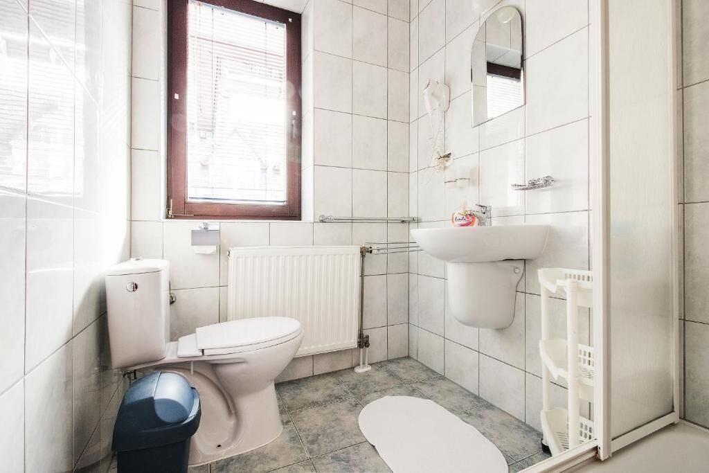 A bathroom with a toilet, sink, and shower.