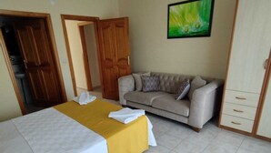 Ein Hotelzimmer mit Bett, einer Couch, einem Kleiderschrank und einem Bild an der Wand.