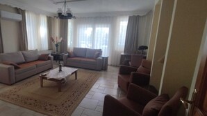Ein großzügiges Wohnzimmer mit zwei Sofas, einem Couchtisch und einer TV-Konsole.