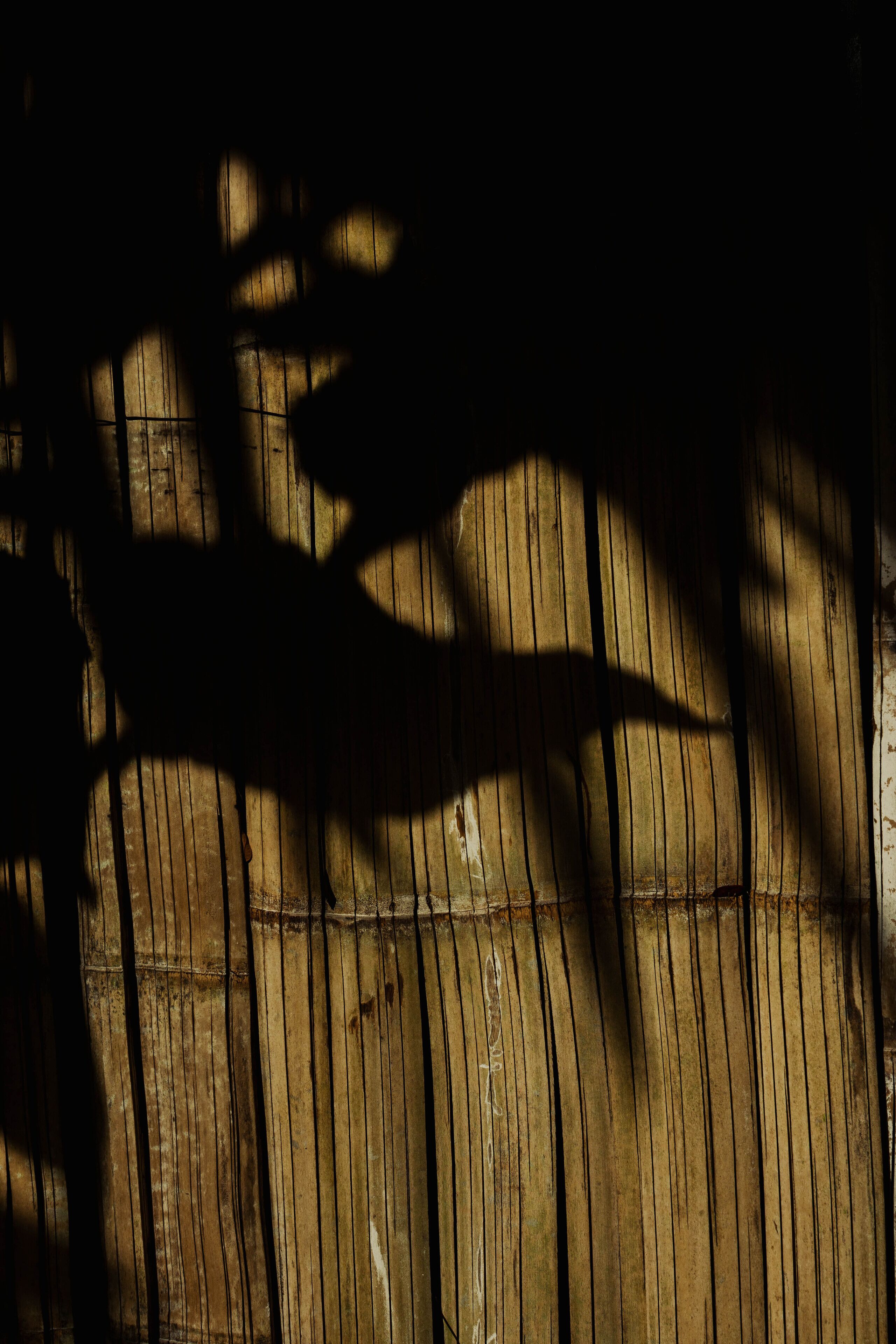 La sombra de una mano sobre una superficie de madera.