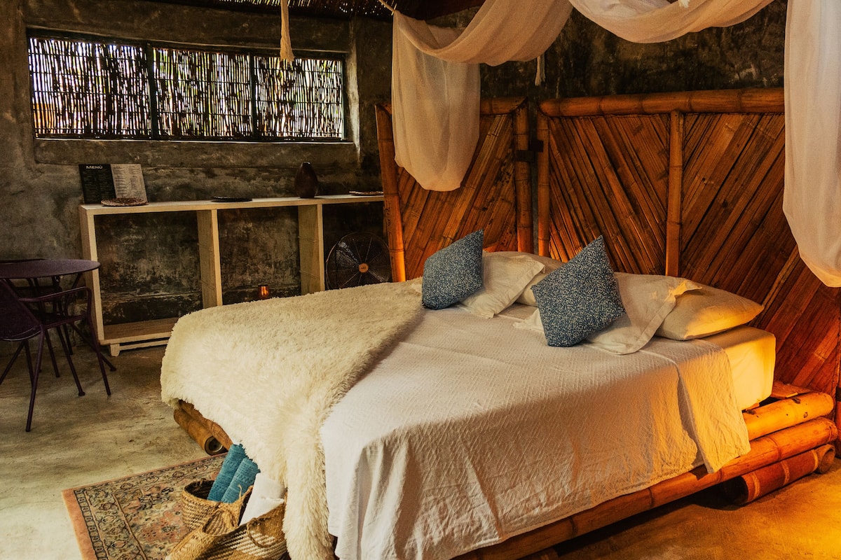 A room with a bed, a small table, and a chair.