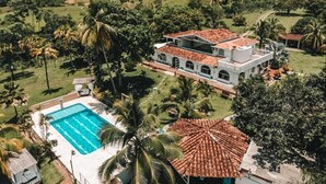 Uma casa grande com piscina e jardim.