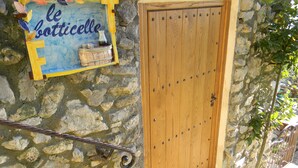 Un mur de pierre avec une porte en bois et une enseigne indiquant « Le Botticelle ».