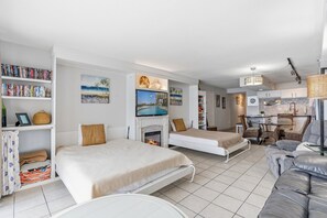 A modern, well-lit room with a bed, a sofa, a dining area, and a kitchen. - Oceans 415-Spacious Oceanfront 1BR- Outdoor Pool (North Myrtle Beach)