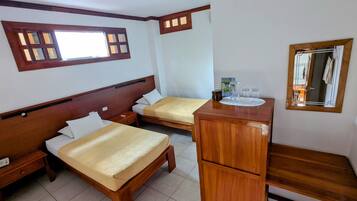 Habitación de hotel con dos camas de madera, una mesita de noche de madera, un escritorio de madera y un espejo.
