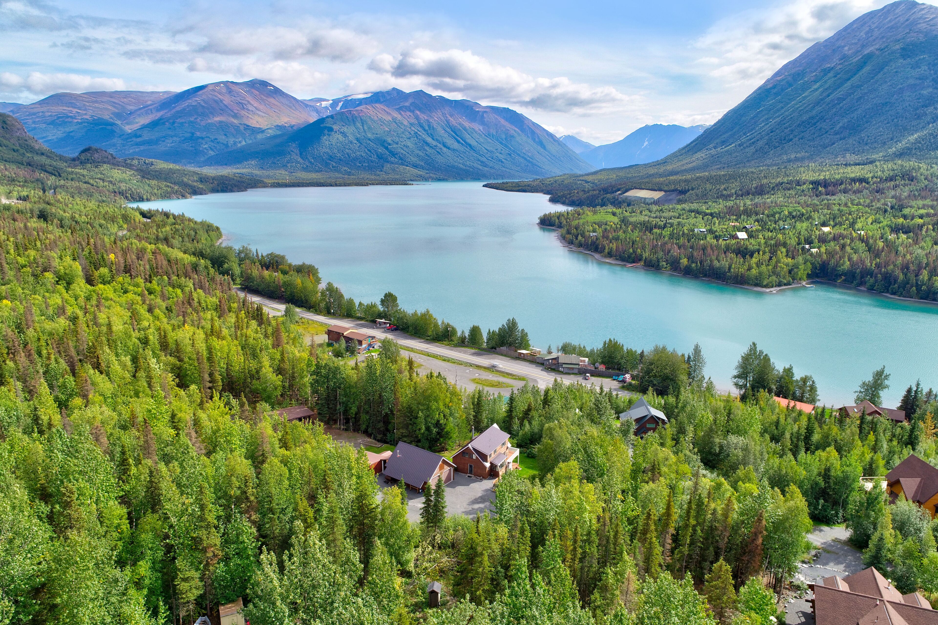 Una proprietà sul lago con baite, un'area parcheggio e una strada che conduce al lago.