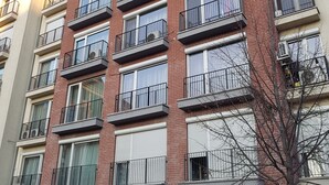 Un edificio residenziale a più piani con balconi, un ingresso per garage e un cartello che indica servizi come fabbro e idraulico.
