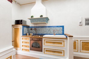 A kitchen with a microwave, oven, sink, and decorative blue backsplash. - ***** THE IMPERIAL SUITE ***** (Roma)
