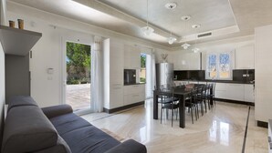 Una cocina moderna con comedor, sofá y un amplio ventanal.