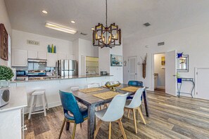 Enjoy meals in the spacious kitchen and dining area, featuring a central island, oven, and dining table with comfortable seating.