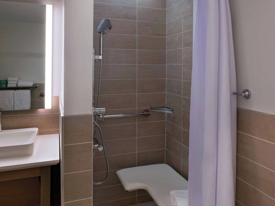 Une salle de bain moderne équipée d’une douche, d’un lavabo et d’un banc.