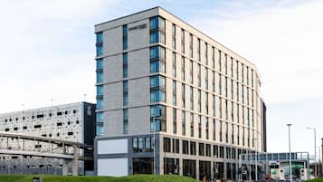 Un hôtel moderne à la façade sobre, doté de grandes fenêtres et d’une galerie couverte.