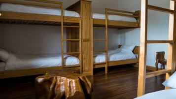 A bunk bed room with a wooden table and a chair.
