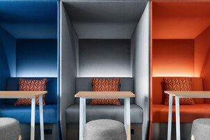 Un interior moderno con tres zonas de estar diferenciadas, cada una con una temática de color y cojines estampados.