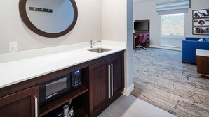 A modern bathroom with a large mirror, a sink, and a built-in microwave. - Hampton Inn & Suites Gilroy (Gilroy)