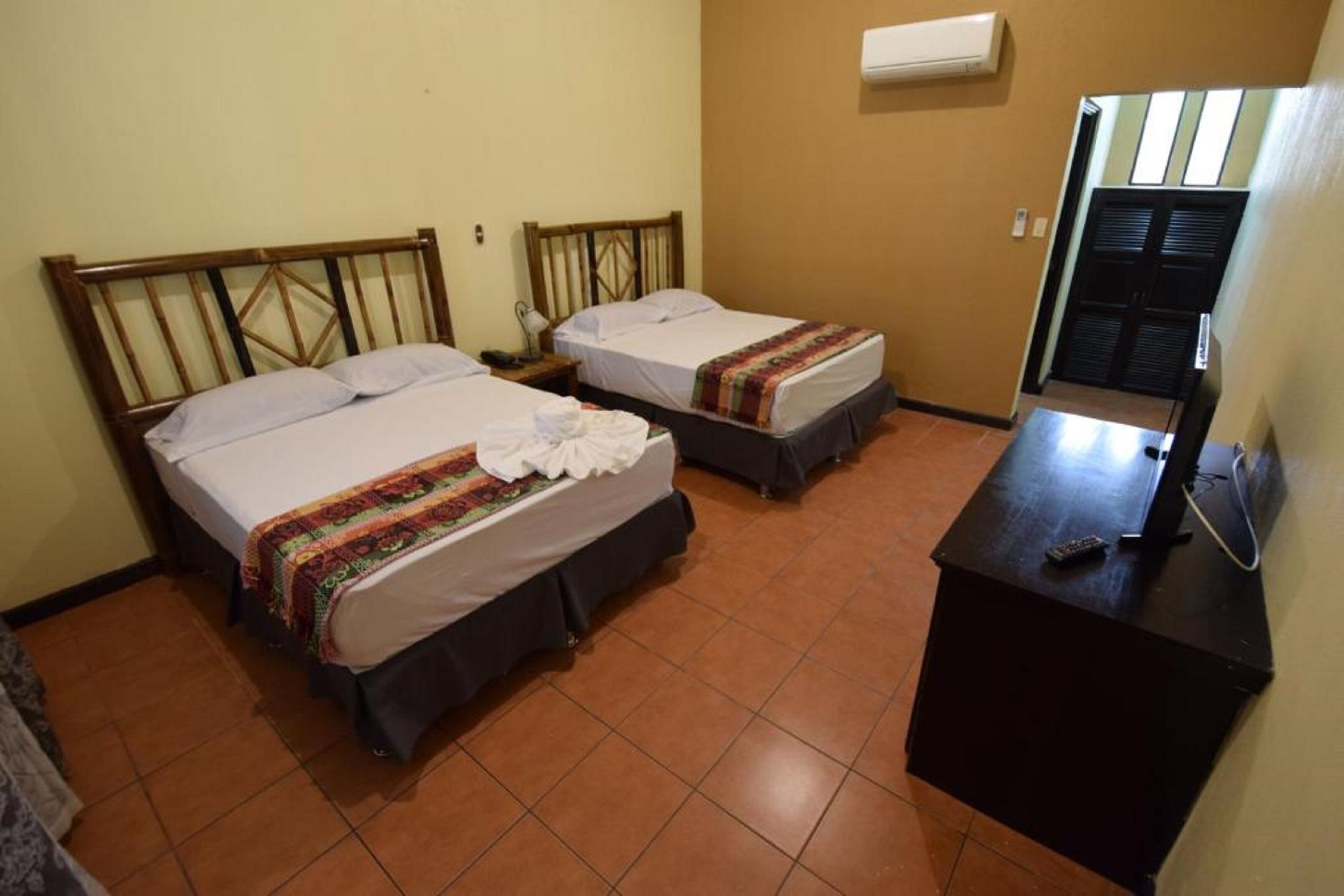Una habitación de hotel con dos camas, un escritorio y una televisión.