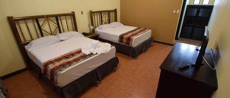 Una habitación de hotel con dos camas, un escritorio y una televisión.