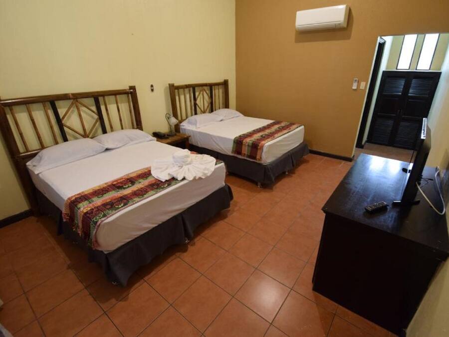 Una habitación de hotel con dos camas, un escritorio y una televisión.