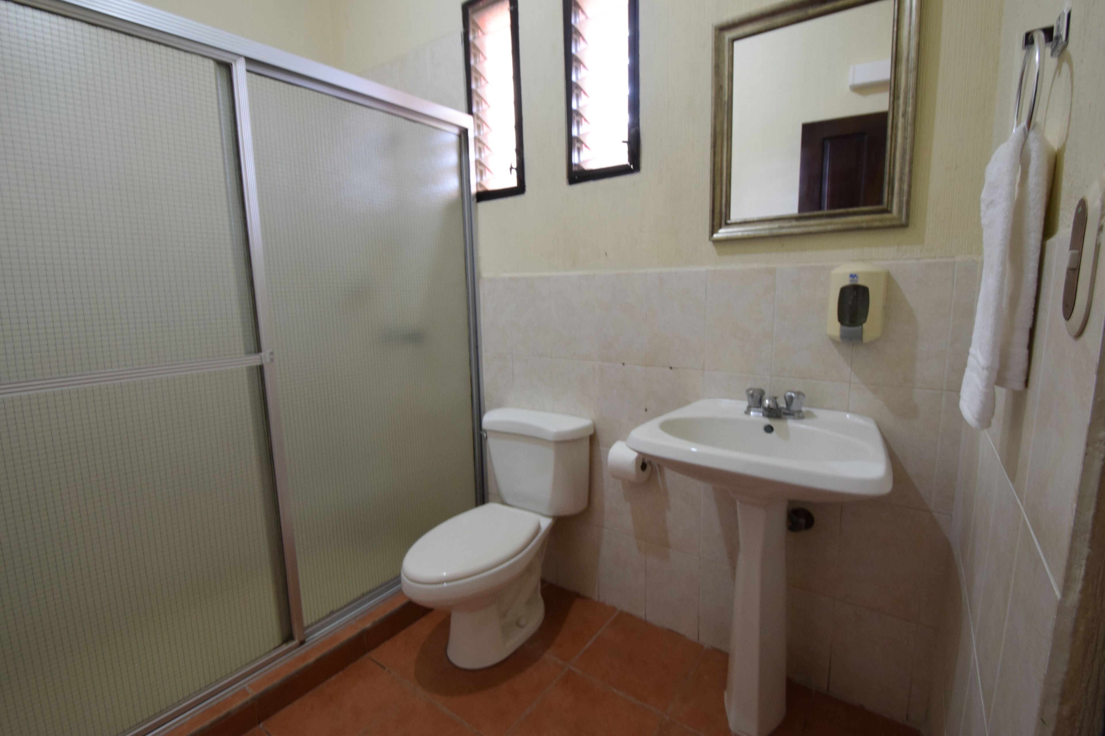 Un baño con inodoro, lavabo y cabina de ducha.