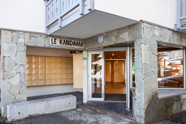 A building with a stone facade, a mailbox, and a door leading inside.