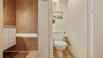 Une salle de bain équipée d’une baignoire, de toilettes et d’un espace douche.