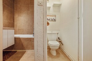Une salle de bain équipée d’une baignoire, de toilettes et d’un espace douche.