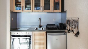 Una cucina compatta con pensili in legno, un lavello in acciaio inossidabile e una lavastoviglie.