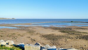 A beach with clear skies, rocky shoreline, and calm waters. - 2 bedroom accommodation in Southerness, near Dumfries (Southerness, near Dumfries)