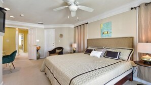 A bedroom with a large bed, a ceiling fan, a nightstand, a chair, and a painting on the wall. - Large 3BR 2.5BA Garage Townhouse in Great West OC Neighborhood with Pool. (Berlin)