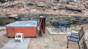 A hot tub, outdoor seating, and a wooden deck.