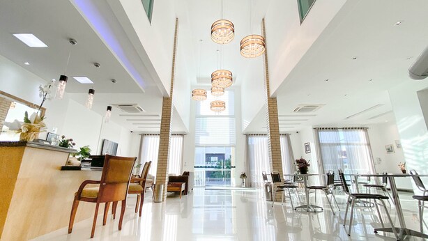 Un moderno vestíbulo de hotel con mostrador de recepción, zona de estar y amplias ventanas.