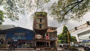 Un edificio de varios pisos que alberga diversos comercios, incluyendo un hotel, un banco y un restaurante.