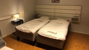 A hotel room with a double bed, bedside tables, a wall-mounted artwork, and a bedside lamp. - Sleep And Go (Harnosand)