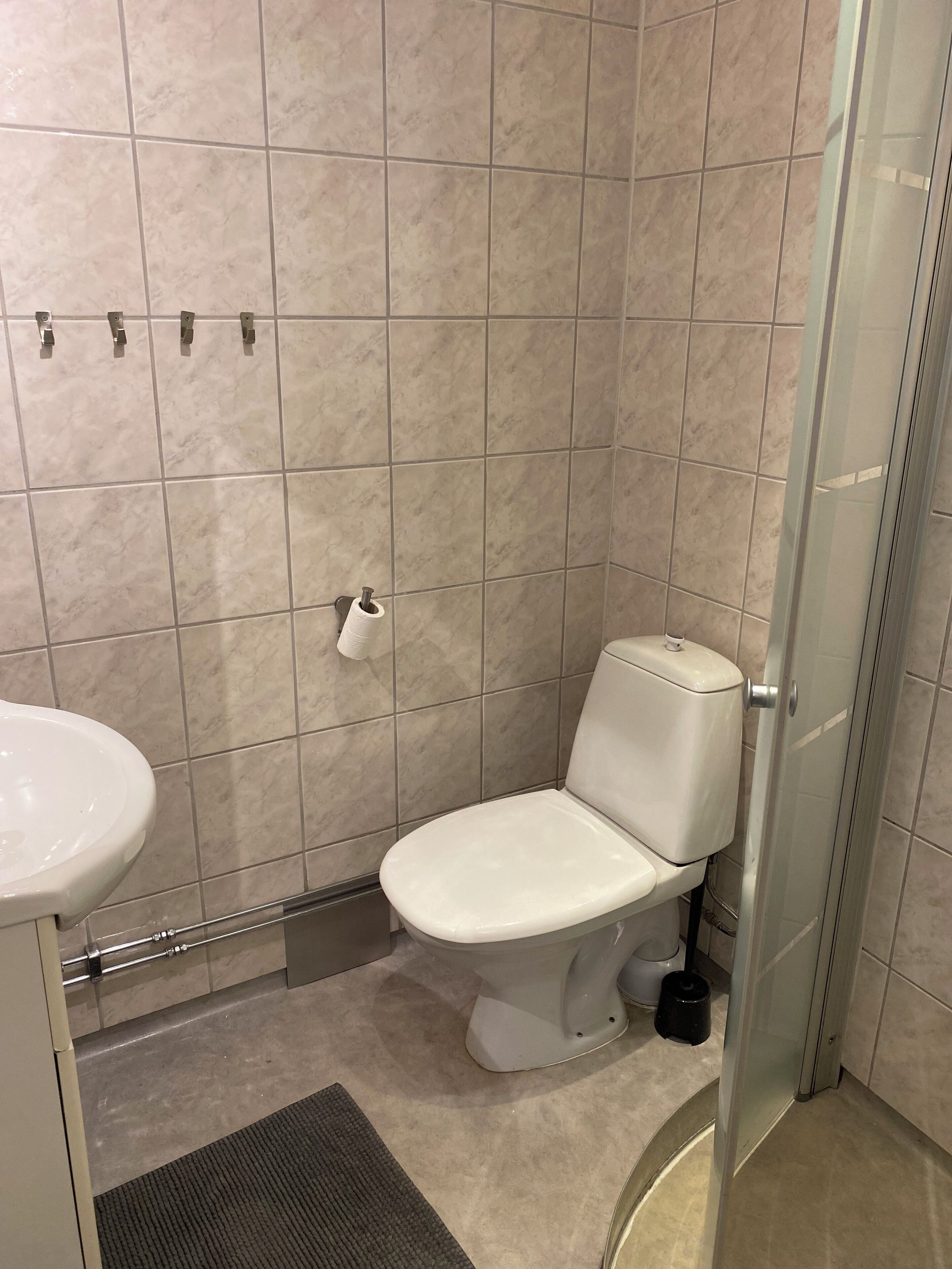 Un baño pequeño y moderno con inodoro, lavabo y ducha.