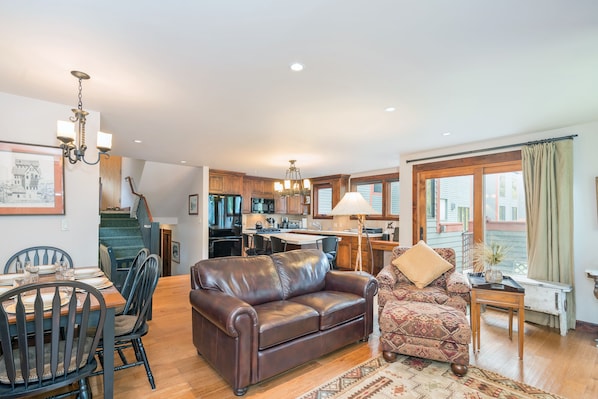 Relax in this inviting living area with a sofa, armchair, and dining table for four, offering a comfortable space to unwind.