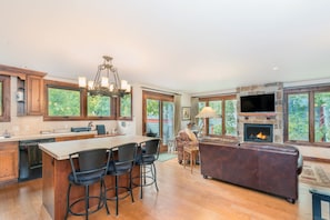 Cozy living area with a fireplace, leather sofa, and dining table.
