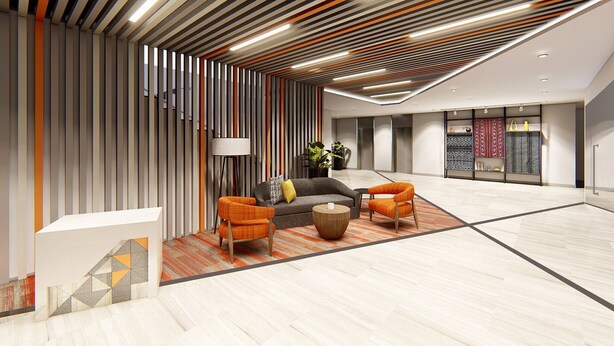 A modern lobby with a reception desk, two orange armchairs, a grey sofa, and a patterned rug. - Citadines Amigo Iloilo (Iloilo)
