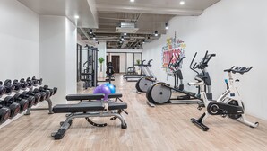 A modern gym with various exercise equipment, including treadmills, stationary bikes, and free weights. - Citadines Amigo Iloilo (Iloilo)